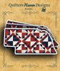 Nebraska state-shaped sticker with red, white, and navy pinwheel quilt blocks