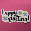 Happy Quilting sticker with black script and pink, purple, aqua, and green quilt stars