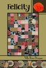 Felicity quilt pattern cover with large blocks in bold red, black, gray-blue, and gold prints